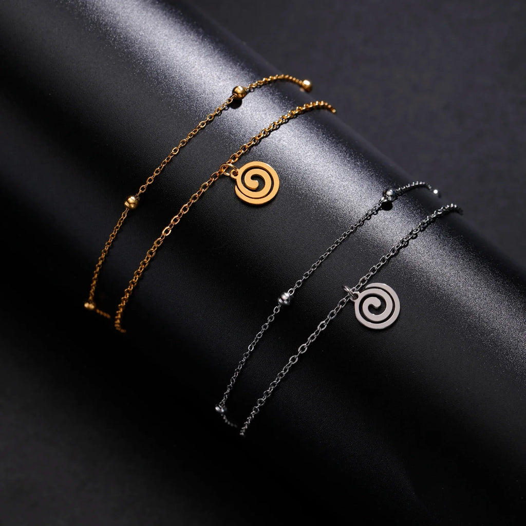 Bracelet doré avec petite breloque spirale argent