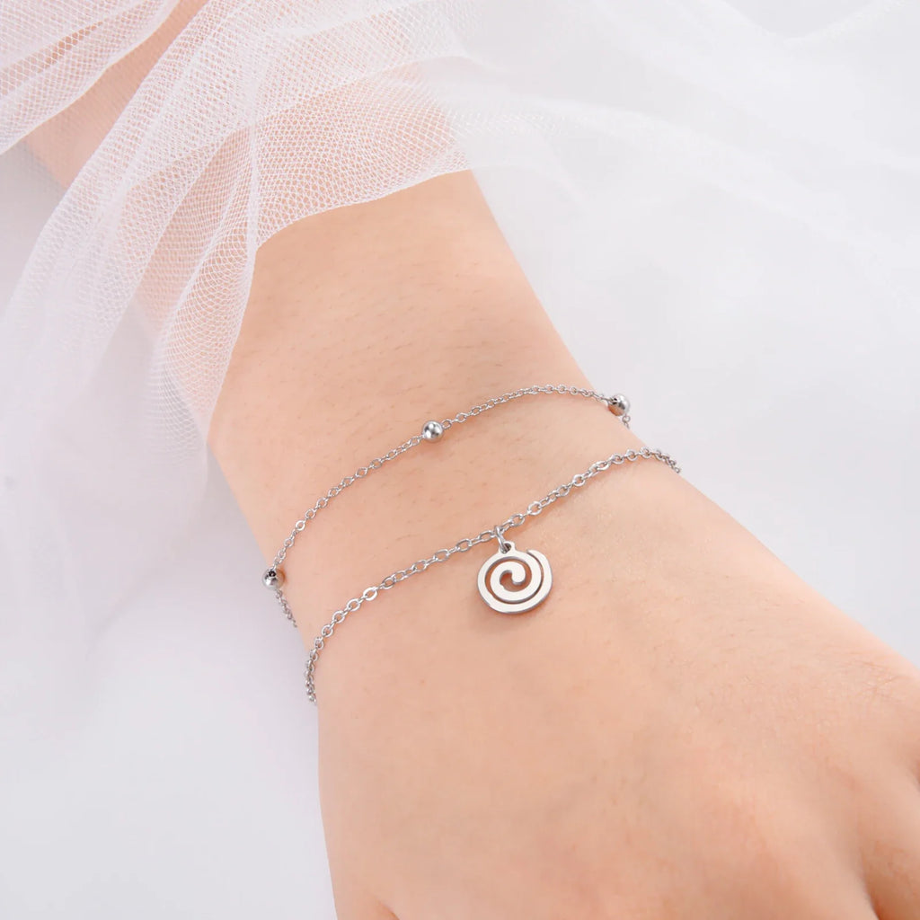Bracelet doré avec petite breloque spirale argent