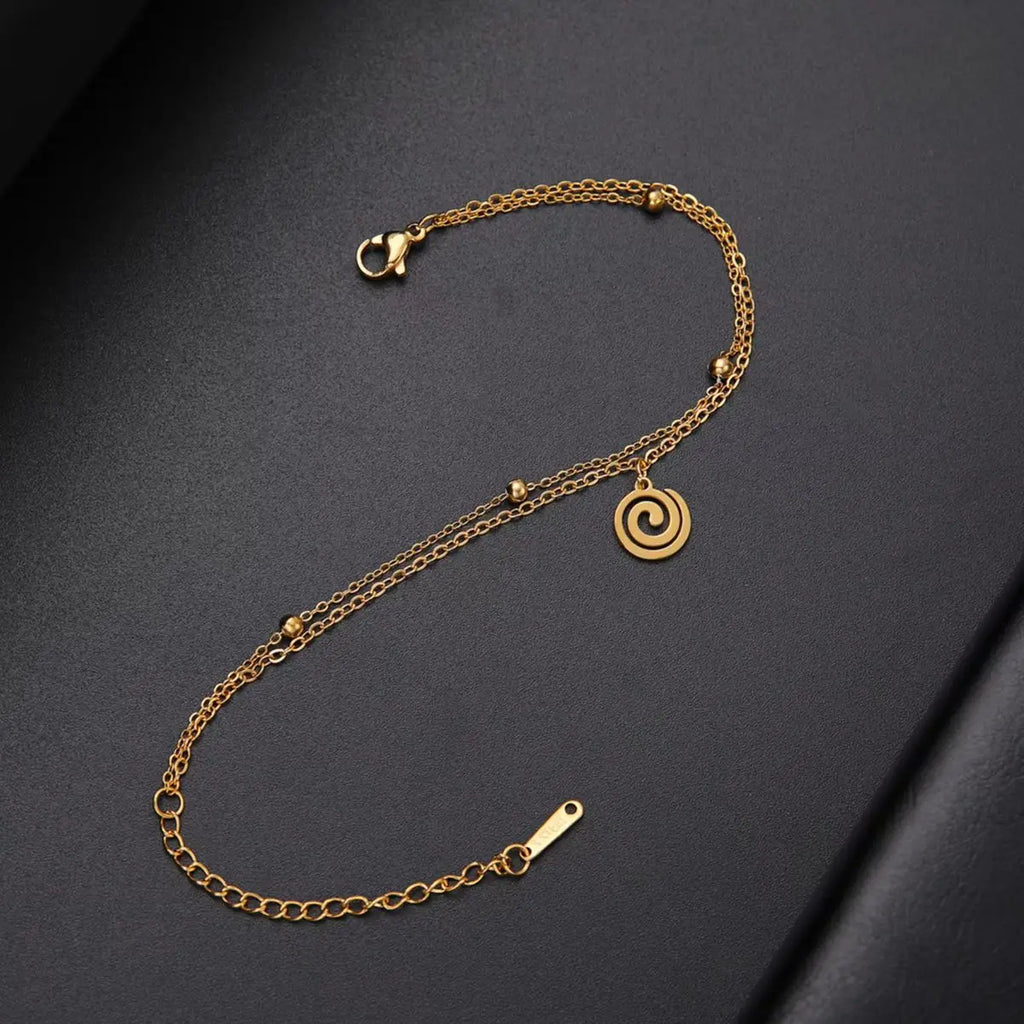 Bracelet doré avec petite breloque spirale or