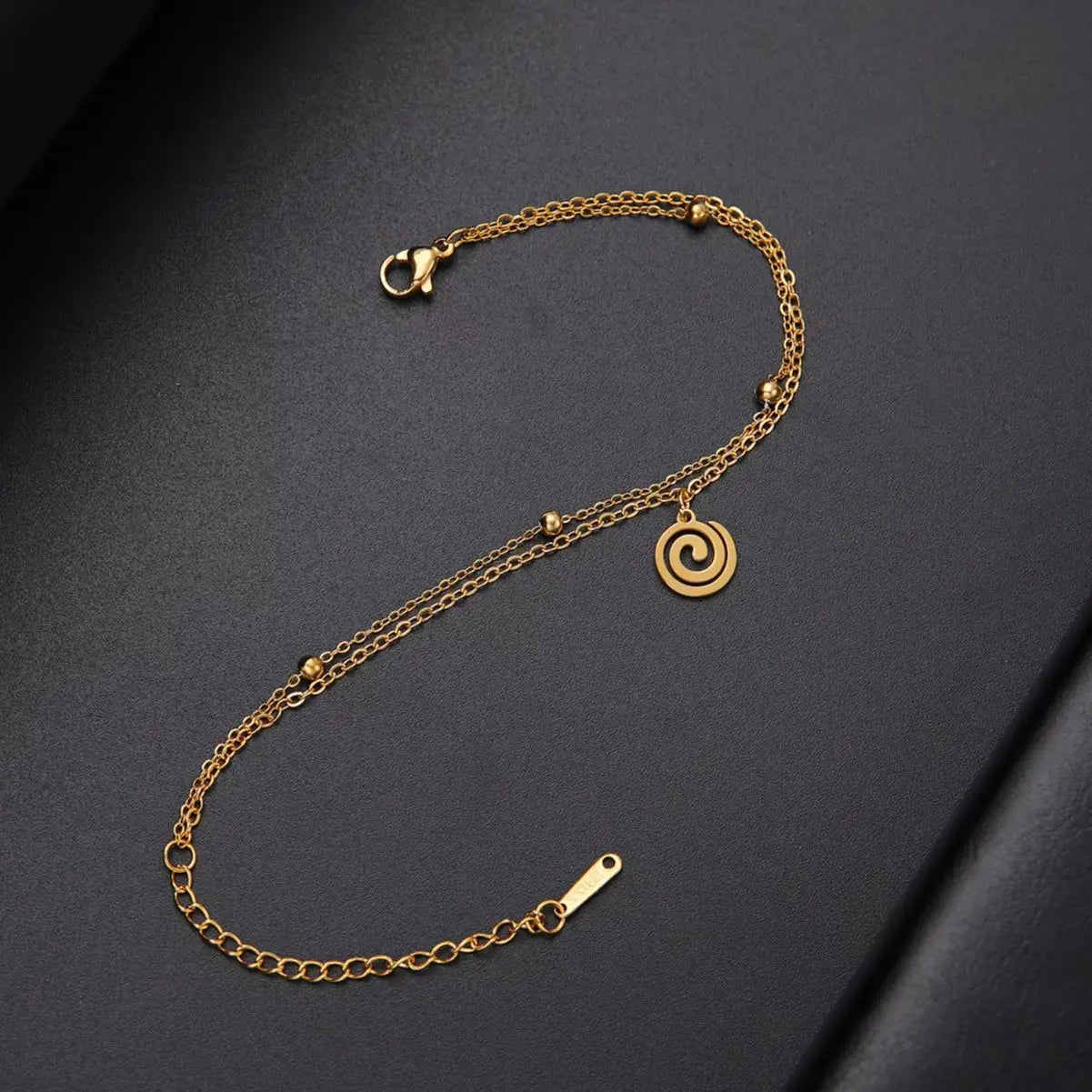 Bracelet doré avec petite breloque spirale or