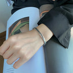 Bracelet jonc ouvert plume argentée