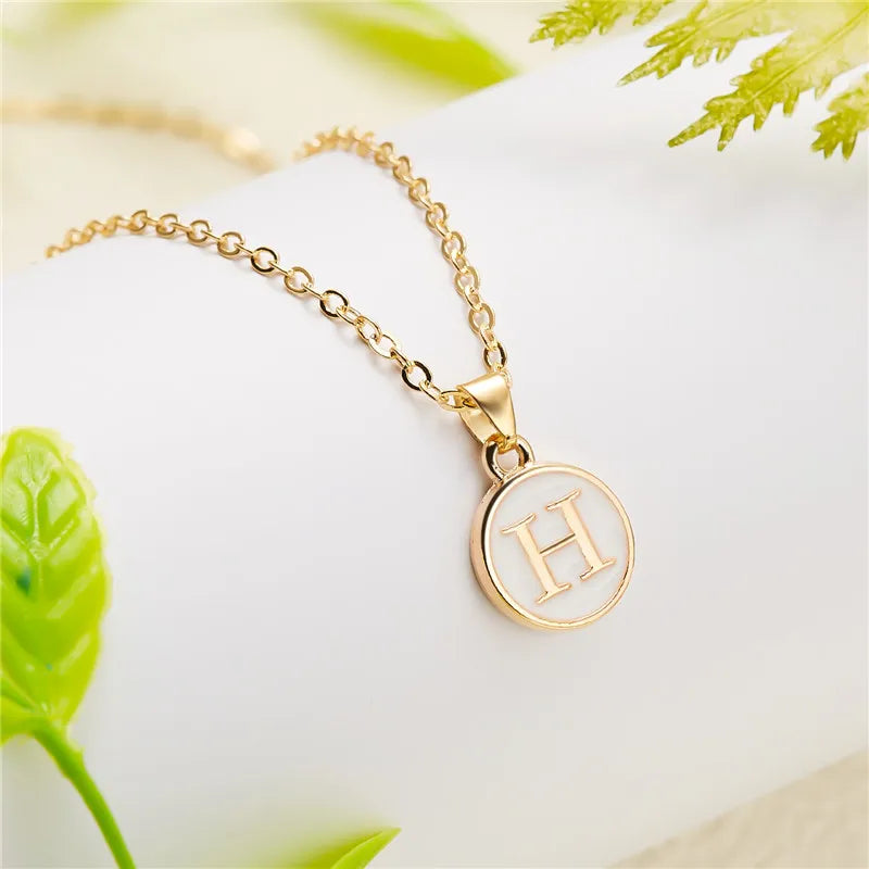 Collier avec pendentif blanc initiale h