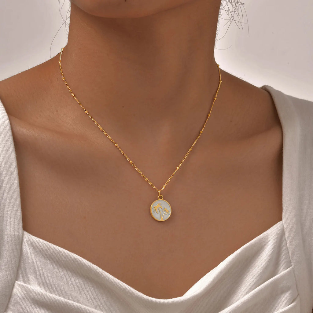 Collier avec pendentif rond et motif palmier