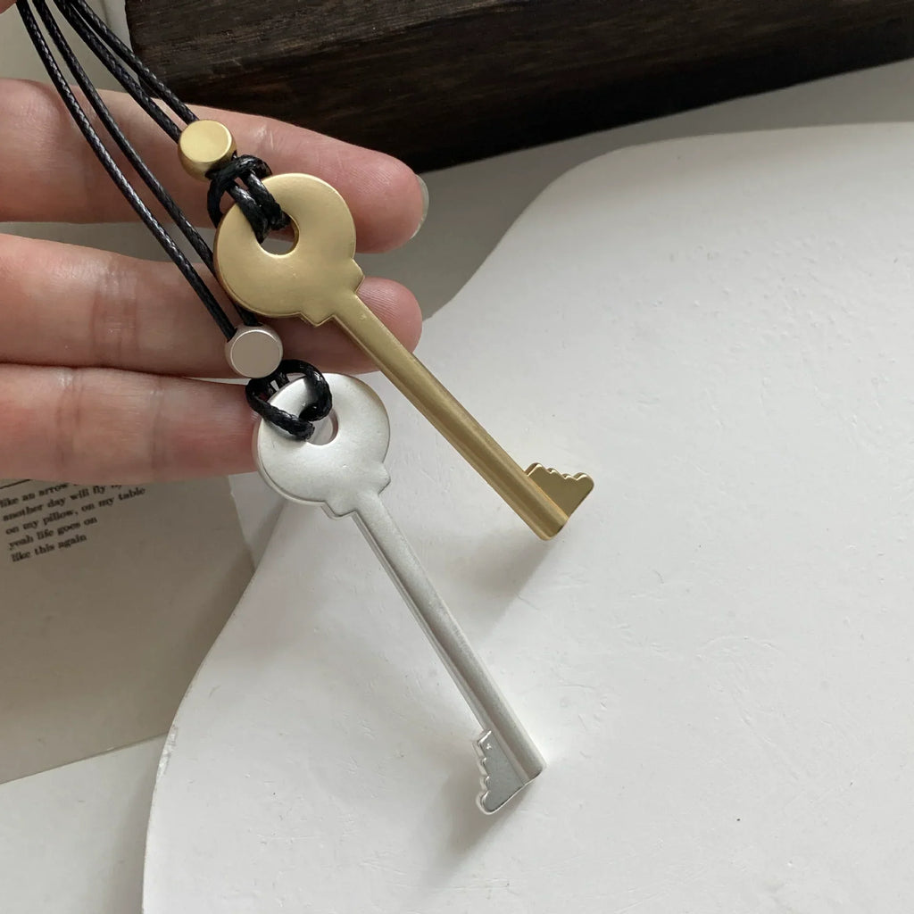 Collier long en corde avec pendentif clef argent mat