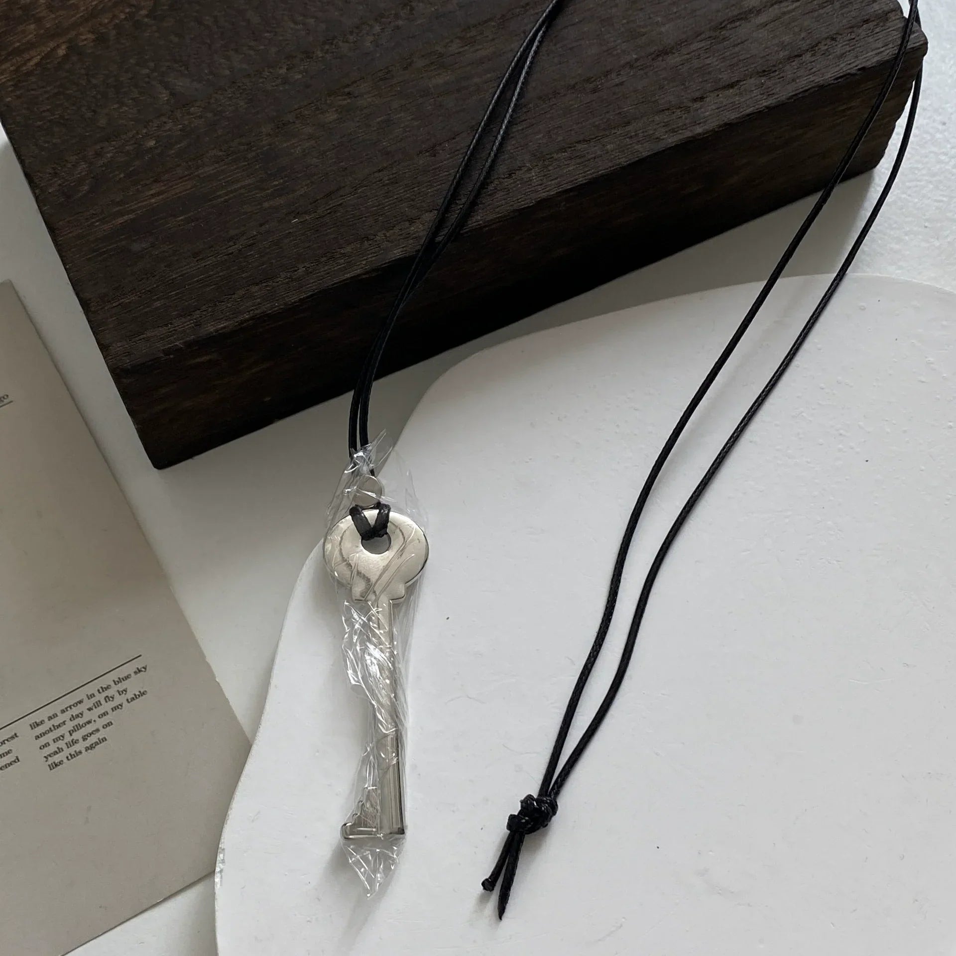 Collier long en corde avec pendentif clef argent brillant