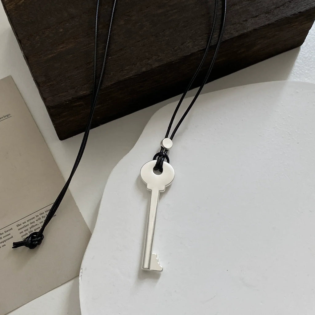 Collier long en corde avec pendentif clef argent mat